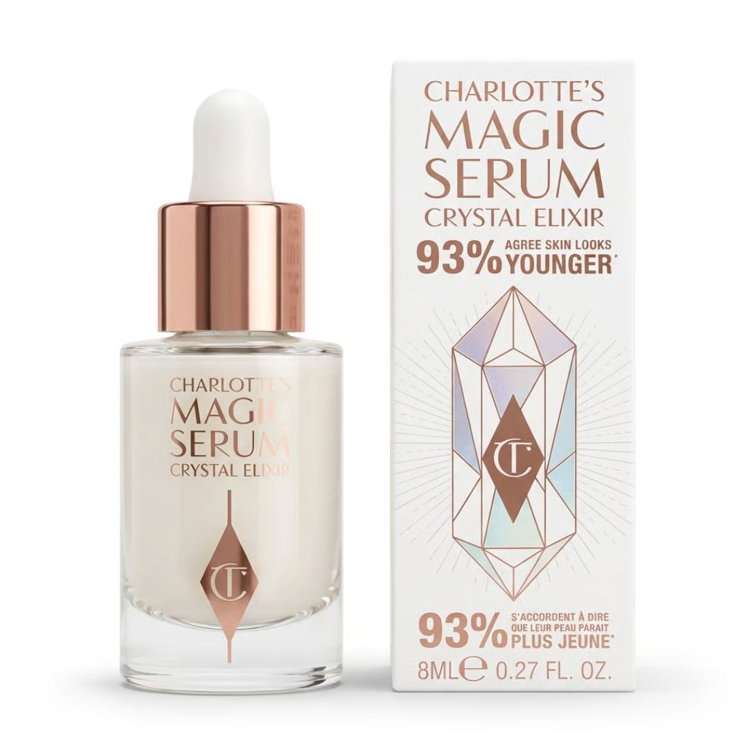 Charlotte's Magic Serum Crystal Elixir in an 8ml glass dropper bottle next to its white packaging box, featuring a rose gold cap and geometric crystal graphic.
