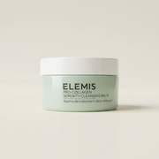 Elemis Pro-Collagen Serenity Cleansing Balm in a light mint green jar with a white lid, centered on a warm off-white background.